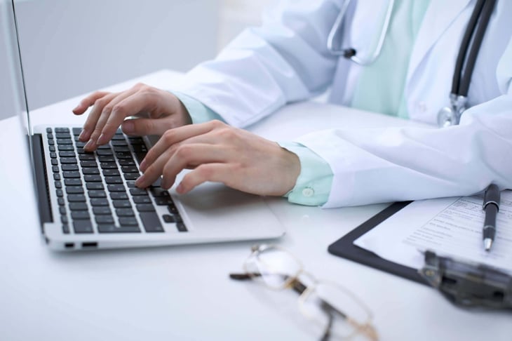 Close-up-of-a-female-doctor-typing-on-laptop-computer,-sitting-at-the-table-in-the-hospital-867698684_2125x1416 (1) (1)-2