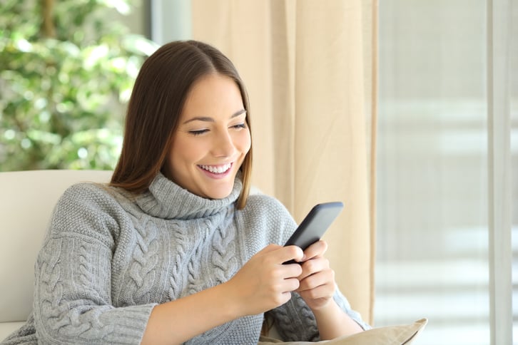 Woman-texting-on-phone-in-winter-627627470_3869x2579