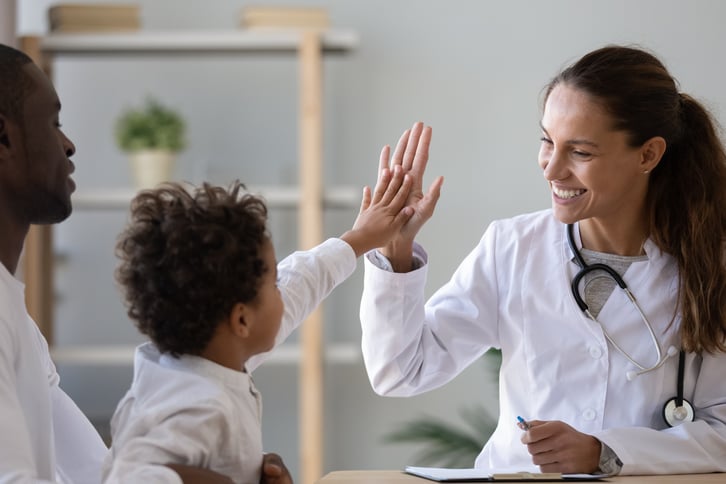 female-european-adult-doctor-consultation-room-giving-high-five-to-child-patient-print