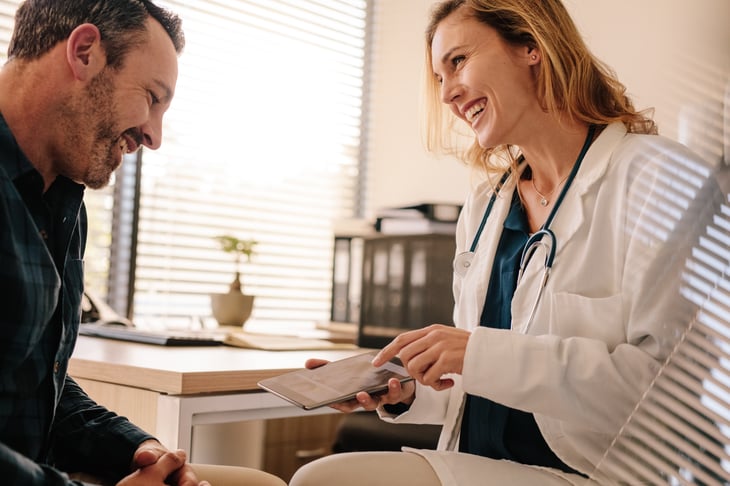 female-european-adult-doctor-consultation-room-showing-good-test-results-to-a-male-patient-print
