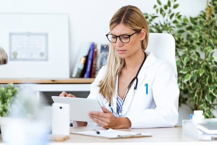 female-european-adult-doctor-consultation-room-using-her-digital-tablet-in-the-consultation-print
